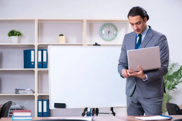 Jeune homme d'affaires debout devant le tableau blanc — Photo