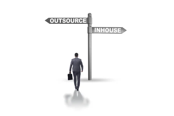 Uomo d'affari all'incrocio che decide tra outsourcing e inhou — Foto Stock