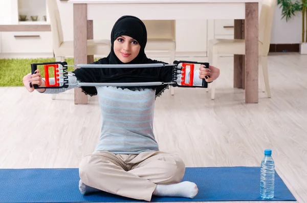 Jonge vrouw in hijab doet oefeningen thuis — Stockfoto