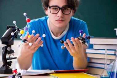 Sınıftaki genç erkek öğrenci.