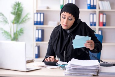 Ofiste çalışan tesettürlü kadın muhasebeci.