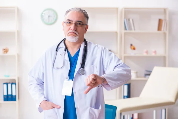 Gammal manlig läkare som arbetar på kliniken — Stockfoto