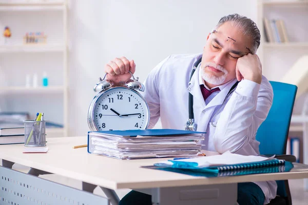 Gammal manlig läkare som arbetar på kliniken — Stockfoto