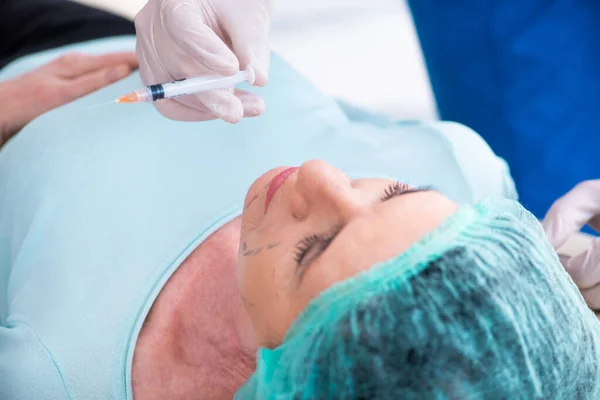 Oude vrouw bezoekt mannelijke arts voor plastische chirurgie — Stockfoto