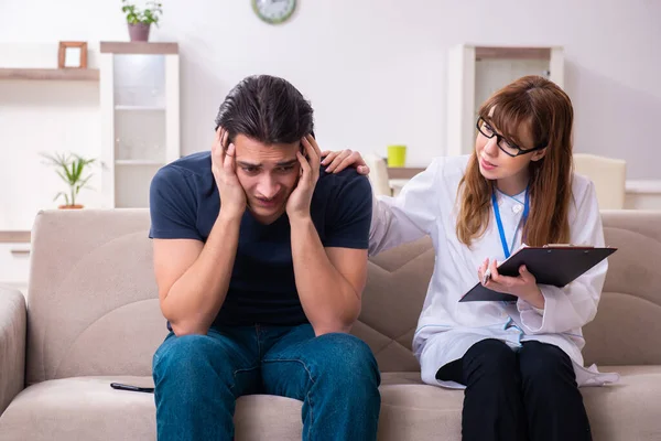 Ung manlig patient diskuterar med kvinnlig psykolog personlig — Stockfoto
