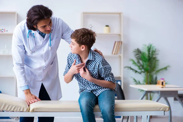 Young doctor examining schoolboy for regular check-up — 스톡 사진