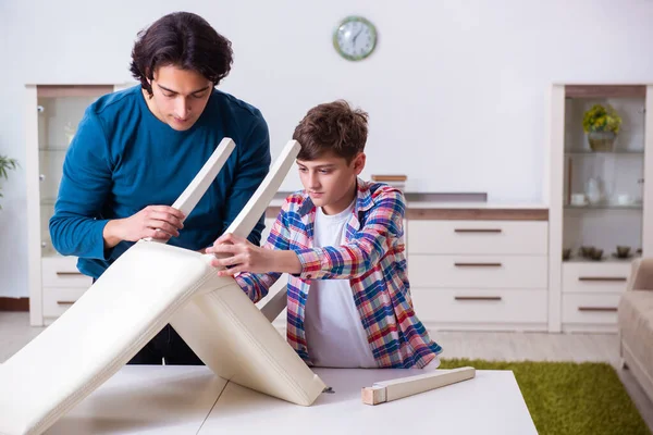 Jovem carpinteiro ensinando seu filho — Fotografia de Stock