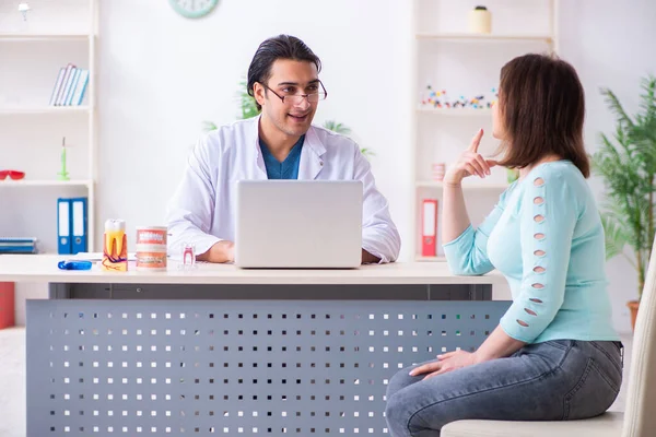 Orta yaşlı bir kadın, erkek doktor stomatoloğu ziyaret ediyor. — Stok fotoğraf