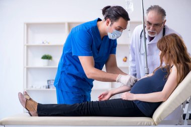 İki doktor genç kadını muayene ediyor.