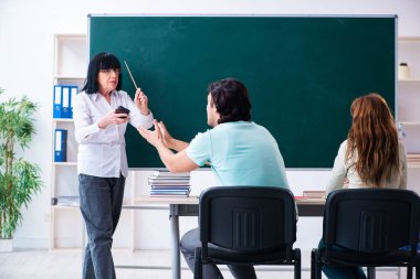 Eski öğretmen ve öğrenciler sınıfta.