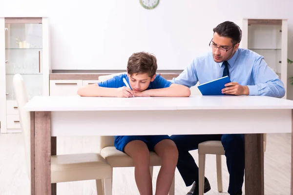 Rušný otec pomáhá svému synovi připravit se na zkoušku — Stock fotografie