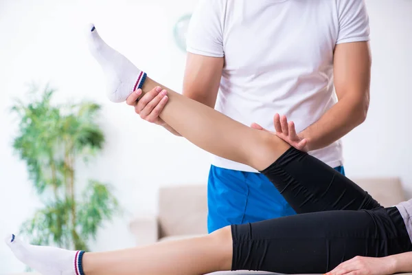 Mujer joven que visita al médico fisioterapeuta masculino — Foto de Stock