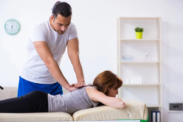 Mujer joven que visita al médico fisioterapeuta masculino — Foto de Stock