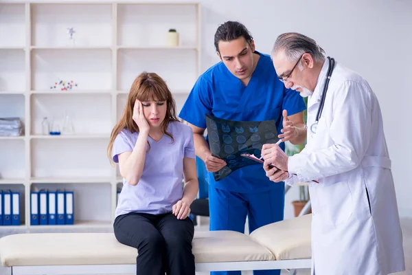 İki doktor genç kadını muayene ediyor. — Stok fotoğraf