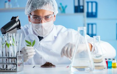 Erkek bilim adamı bir laboratuarda deney yapıyor.