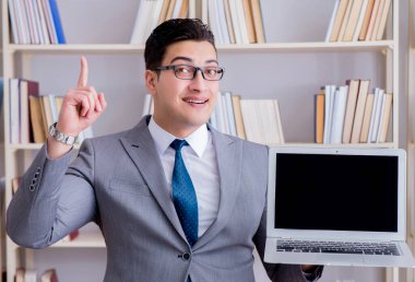 Kütüphanede çalışan boş ekran bilgisayarı olan bir iş adamı.