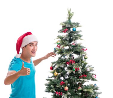 Genç adam beyaz üzerine izole edilmiş noel ağacını süslüyor.
