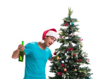 Genç adam beyaz üzerine izole edilmiş noel ağacını süslüyor.