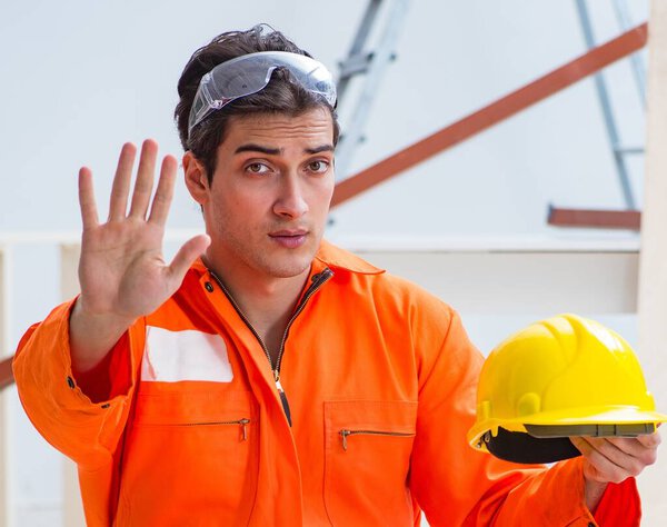 Плотник в жёлтой каске в мастерской подрядчика