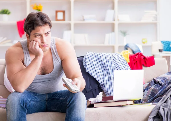 Jongeman aan het werk in rommelige kamer — Stockfoto