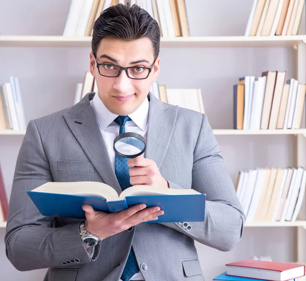 Estudiante de derecho empresarial con lupa leyendo un libro —  Fotos de Stock