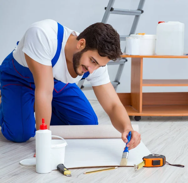 Riparatore fare riparazione ristrutturazione in casa con carta da parati — Foto Stock