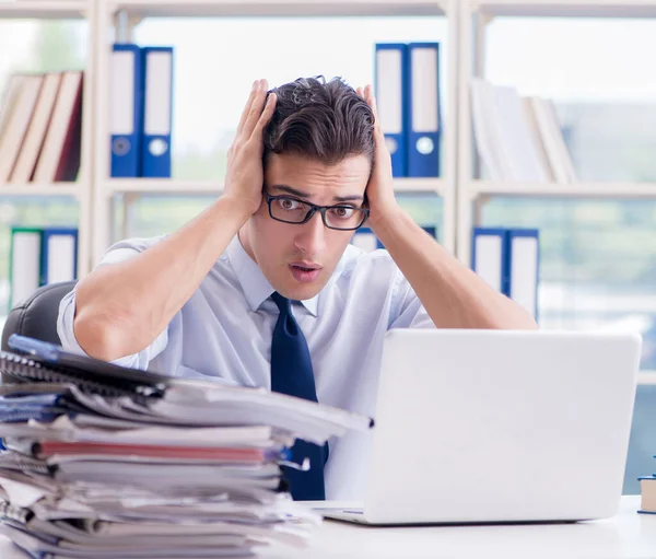 Homme d'affaires avec une paperasserie de travail excessive travaillant dans le bureau — Photo