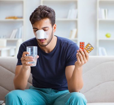 Genç adam estetik cerrahi burnundan sonra evde iyileşiyor.