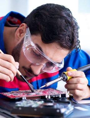 Bilgisayar dizüstü bilgisayarının tamirinde çalışan tamirci.