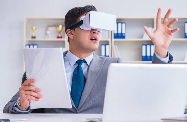 Modern teknolojide sanal gerçeklik gözlüklü bir iş adamı.