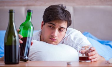 Yatakta içen alkolik adam depresyona giriyor.