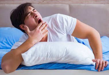 Uykusuzluk çeken bir adam yatakta yatıyor.