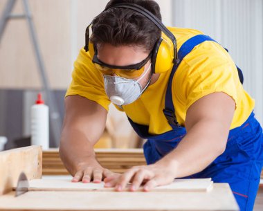 Genç bir marangoz dairesel testere ile çalışıyor.