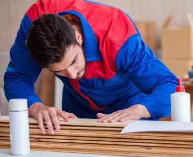 Yooung marangoz boyayla uğraşıyor.