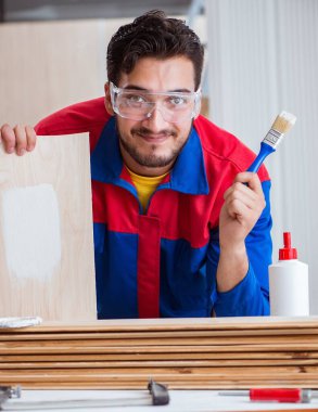 Yooung marangoz boyayla uğraşıyor.