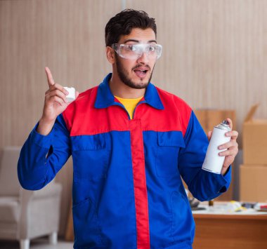 Yooung marangoz boyayla uğraşıyor.