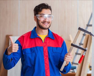 Klemplerle çalışan genç bir tamirci.