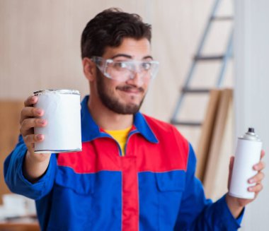 Yooung marangoz boyayla uğraşıyor.