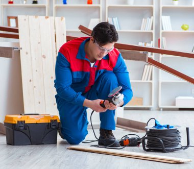 Genç marangoz ahşap kalaslarla çalışıyor.