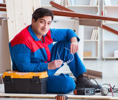 Genç marangoz ahşap kalaslarla çalışmaya ara veriyor.