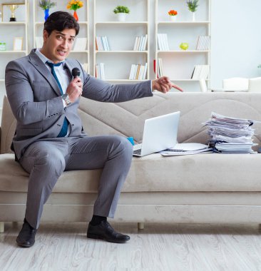 Üzgün işadamı ofiste şarkı söylüyor.