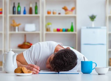 Fazla mesai sonrası kahvaltıda uyuyan bir adam.