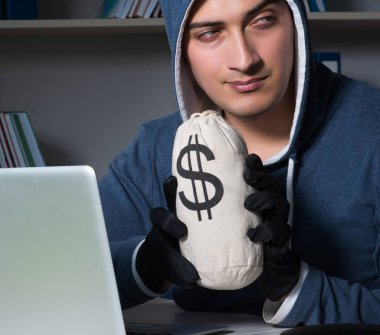 Genç hacker geceleri bilgisayarı hackliyor.