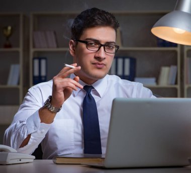 Stres altındaki iş adamı ofiste sigara içiyor