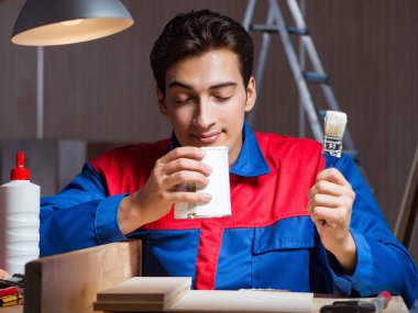 Genç adam ahşap parçaları DIY konseptinde yapıştırıyor.