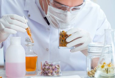 Laboratuvarda parfüm karıştıran bir kimyager.