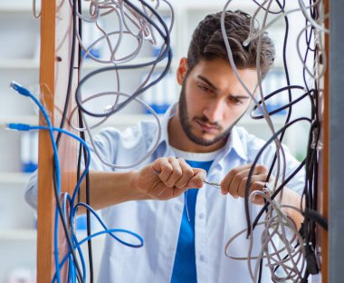 Elektrik teknisyeni tamir konseptinde kabloları çözmeye çalışıyor.
