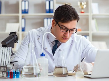 Genç araştırmacı bilim adamı bir su testi kirliliği araştırması yapıyor.