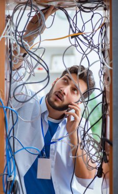Elektrik teknisyeni tamir konseptinde kabloları çözmeye çalışıyor.