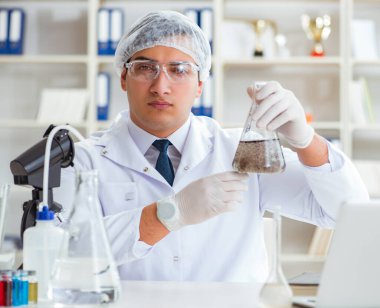 Genç araştırmacı bilim adamı bir su testi kirliliği araştırması yapıyor.